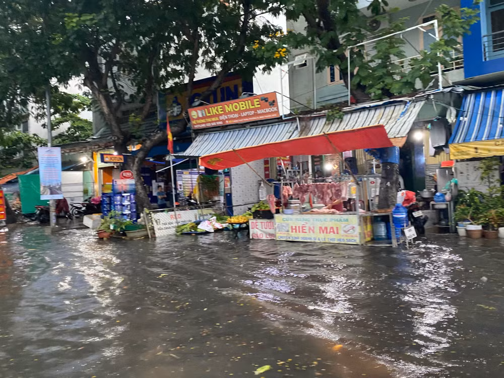 Nước mưa dâng cao làm các hộ dân buôn bán tại tuyến đường Đặng Thùy Trâm, quận Gò Vấp xoay sở kê cao đồ đạc. (Ảnh: QUÝ HIỀN)
