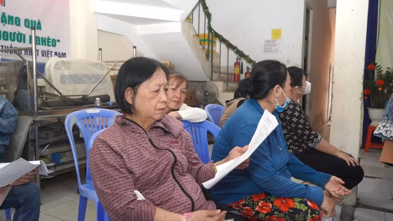 Một người dân xem Phương án chi tiết bồi thường trước khi quyết định hiệp thương với nhân viên Ban bồi thường Quận 8. (Ảnh: THẾ ANH)