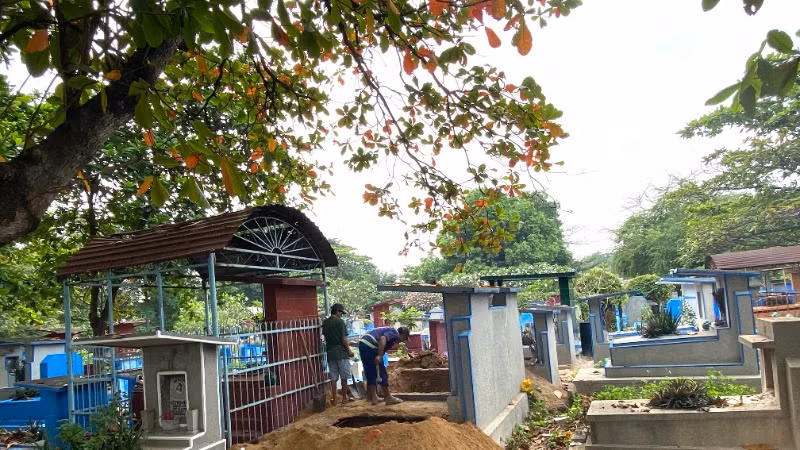 Nhân viên Công ty Môi trường đô thị Thành phố bốc mộ cho thân nhân tại nghĩa trang Bình Hưng Hòa trong tháng 2/205. (Ảnh: QUÝ HIỀN)