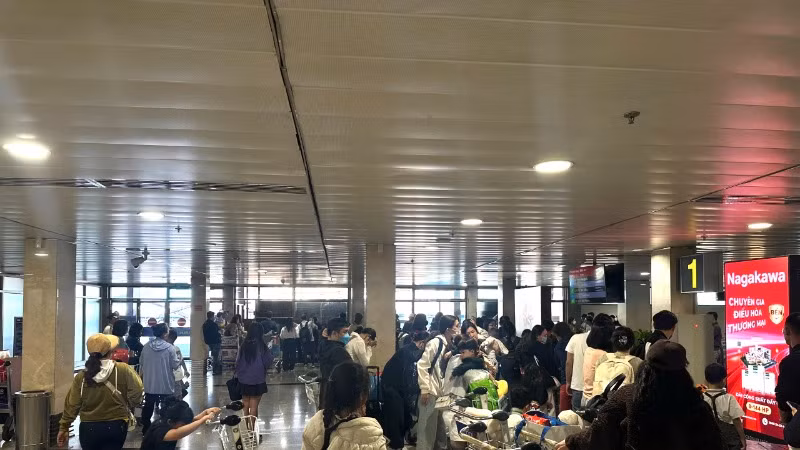 Trong ngày 2/2, có 863 chuyến bay cất và hạ cánh tại sân bay Tân Sơn Nhất. Hành khách chờ lấy hành lý tại sân bay. (Ảnh: QUÝ HIỀN)