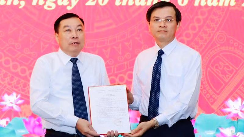 Đồng chí Đoàn Minh Huấn, Ủy viên Trung ương Đảng, Bí thư Tỉnh ủy Ninh Bình trao quyết định cho đồng chí Đinh Văn Tiên. (Ảnh: ĐỨC LAM)