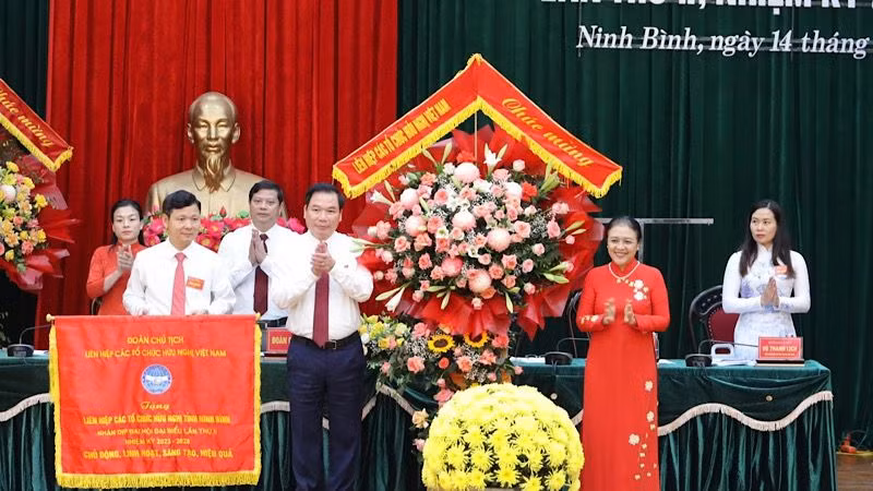 Đồng chí Nguyễn Phương Nga tặng hoa, cờ lưu niệm cho Đại hội. (Ảnh: Minh Quang)