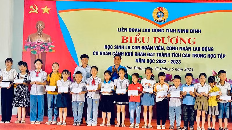 Lãnh đạo Liên đoàn Lao động tỉnh Ninh Bình trao quà cho các học sinh. (Ảnh: XUÂN TRƯỜNG)