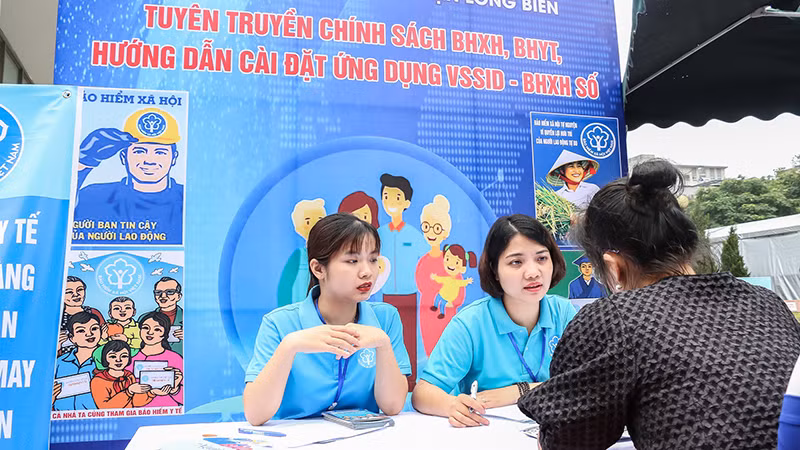 Cán bộ Bảo hiểm xã hội quận Long Biên, Hà Nội giới thiệu chính sách với người lao động. (Ảnh: NGÂN ANH)