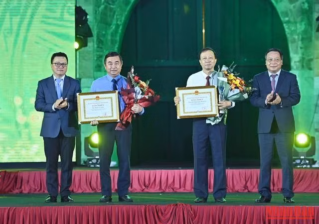 Tổng Biên tập báo Nhân Dân, Chủ tịch Hội Nhà báo Việt Nam Lê Quốc Minh và Phó Bí thư Thành ủy trao tặng bằng khen cho các cơ quan báo chí có đóng góp nhiều tác phẩm chất lượng cao cho Giải báo chí. (Ảnh: DUY LINH)