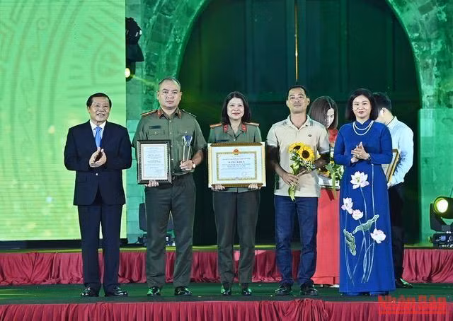 Phó Trưởng Ban thường trực Ban Tuyên giáo Trung ương Lại Xuân Môn và Phó Bí thư thường trực Thành ủy Nguyễn Thị Tuyến trao giải A cho các tác giả. (Ảnh: DUY LINH)