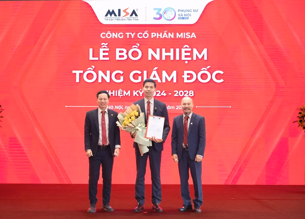 Chủ tịch HĐQT MISA Lữ Thành Long (bên phải) và Phó Chủ tịch HĐQT MISA Nguyễn Xuân Hoàng (bên trái) trao hoa và quyết định bổ nhiệm Tổng Giám đốc cho ông Lê Hồng Quang.