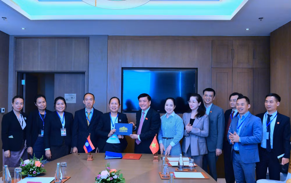 Tổng Thư ký Quốc hội, Chủ nhiệm Văn phòng Quốc hội Bùi Văn Cường tặng quà lưu niệm Tổng Thư ký Quốc hội Lào Pingkham Lasasimma. (Ảnh: quochoi.vn)