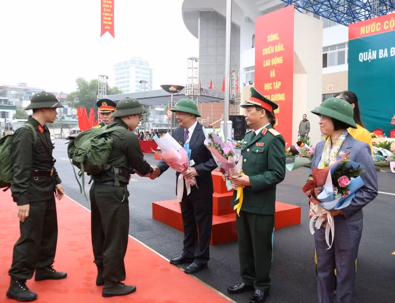 Bí thư Thành ủy Hà Nội Đinh Tiến Dũng tặng hoa cho các tân binh. 