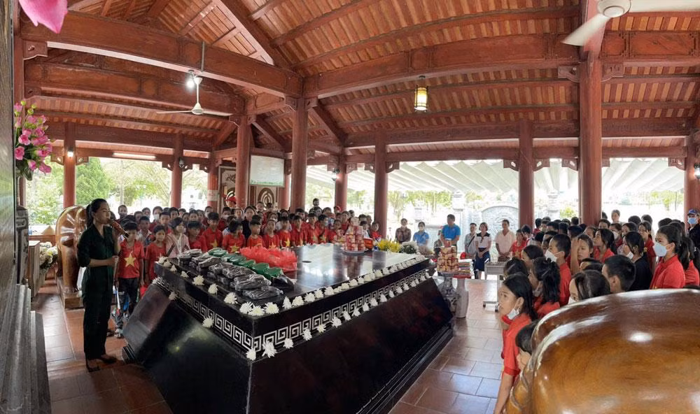 Du khách tham quan, tìm hiểu nhiều hình ảnh tư liệu về Bác Hồ, về quan hệ Việt-Lào được trưng bày tại khuôn viên Khu di tích Kim Liên. (Ảnh: THU THỦY)