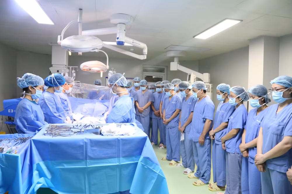Các y bác sĩ cúi đầu tri ân người hiến tạng trước khi phẫu thuật.