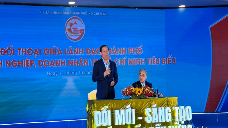 Chủ tịch Ủy ban nhân dân Thành phố Hồ Chí Minh Phan Văn Mãi (người đứng) và Chủ tịch HUBA Nguyễn Ngọc Hòa đối thoại với doanh nghiệp, doanh nhân tại buổi lễ.