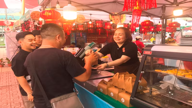 Khách mua món ăn tại một gian hàng trong lễ hội