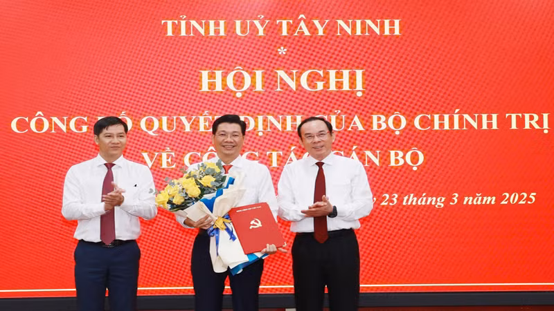 Đồng chí Nguyễn Văn Nên, Ủy viên Bộ Chính trị, Bí thư Thành ủy Thành phố Hồ Chí Minh (phải) và đồng chí Nguyễn Thành Tâm, Ủy viên Trung ương Đảng, Phó Trưởng ban Tổ chức Trung ương, trao quyết định, tặng hoa chúc mừng đồng chí Nguyễn Mạnh Hùng.