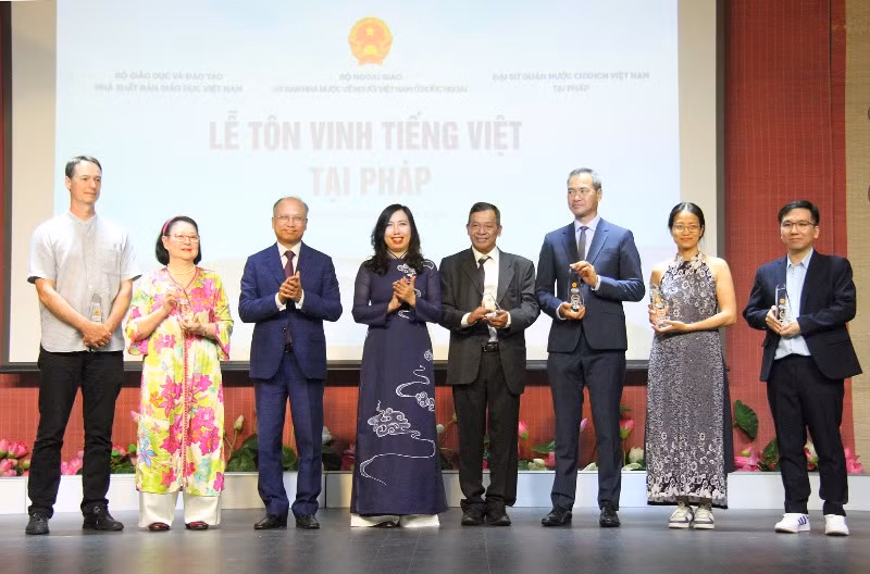 Thứ trưởng Lê Thị Thu Hằng và Đại sứ Đinh Toàn Thắng trao tặng Kỷ niệm chương cho các tập thể và cá nhân có nhiều đóng góp đối với công tác gìn giữ và lan tỏa tiếng Việt tại Pháp. (Ảnh: KHẢI HOÀN)
