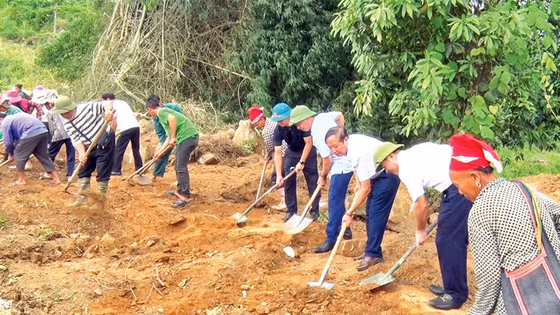 Cán bộ tham gia mở rộng đường nông thôn với người dân địa phương.