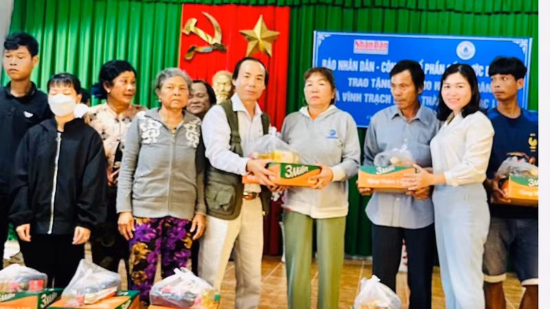 Nhà báo Trọng Duy, đại diện Cơ quan Thường trực Báo Nhân Dân tại Cần Thơ và đồng chí Ngô Yến Nhiên, Bí thư Đảng ủy xã Vĩnh Trạch Đông trao quà các hộ nghèo của xã.