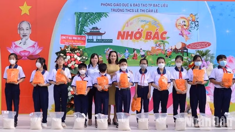 Cô Trần Kim Thi, Hiệu trưởng Trường trung học cơ sở Lê Thị Cẩm Lệ (thành phố Bạc Liêu) trao quà, gạo những học sinh có hoàn cảnh khó khăn của trường. (Ảnh TRỌNG DUY)
