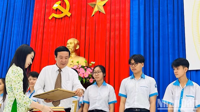 Thầy giáo Nguyễn Văn Bình, Trưởng phòng Giáo dục và Đào tạo thị xã Giá Rai (Bạc Liêu) tặng giấy khen và quà những học sinh khó khăn, học giỏi. (Ảnh: TRỌNG DUY)