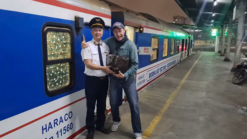 Trưởng tàu Dương Văn Toản trả lại chiếc túi bỏ quên cho ông Max kumm.