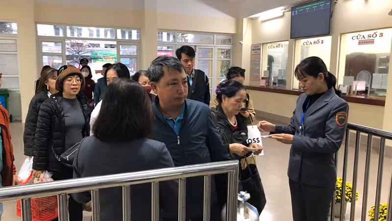 Nhân viên khách vận kiểm soát vé khách vào ga đi tàu.