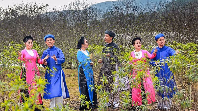 Các thành viên CLB dân ca ví, giặm xã Xuân Giang (Nghi Xuân) biểu diễn trong không gian vườn đào tại xã Cổ Đạm