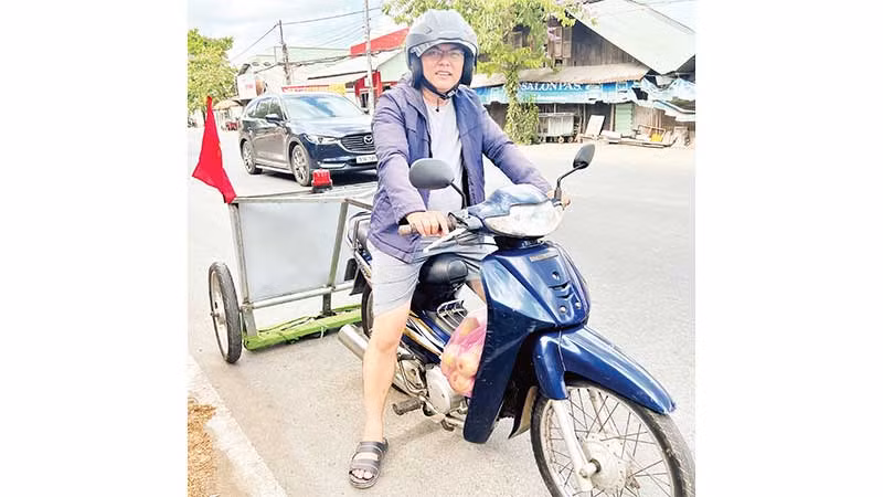 Anh Trần Khắc Vũ cùng xe tự chế hút đinh, vật sắc nhọn giúp bảo đảm an toàn giao thông.