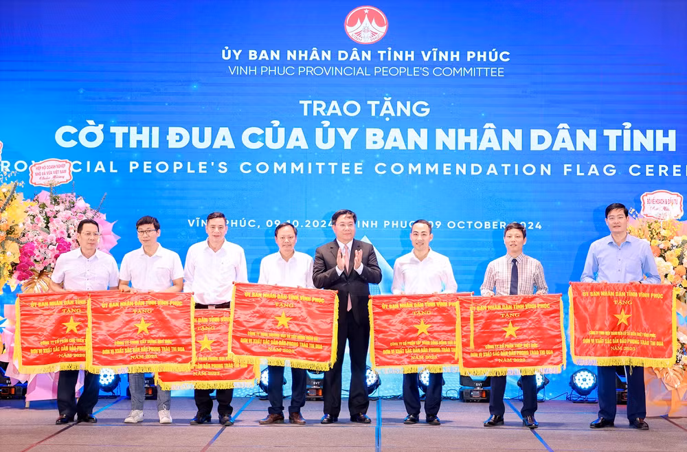 Chủ tịch Ủy ban nhân dân tỉnh Trần Duy Đông trao Cờ thi đua cho các doanh nghiệp tiêu biểu.