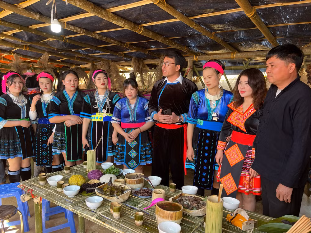 Chủ tịch UBND xã Dào San Vương Biên Thùy (đứng giữa) giới thiệu món ăn truyền thống của người Mông.