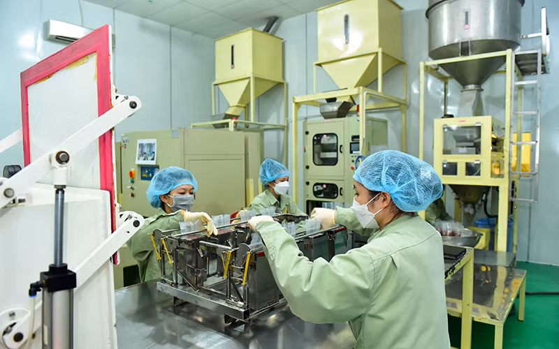 Đóng gói gạo "Sức sống Mekong" tại Nhà máy lương thực Vĩnh Hưng (huyện Vĩnh Hưng, Long An).