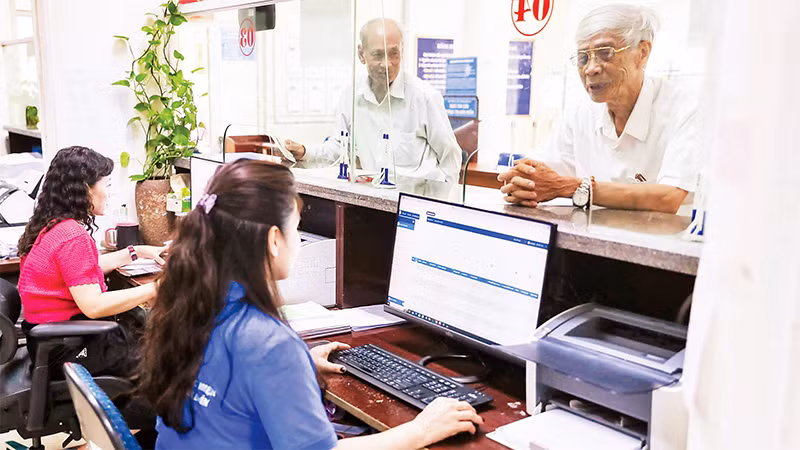 Người dân làm thủ tục bảo hiểm xã hội, bảo hiểm y tế tại bộ phận một cửa của Bảo hiểm xã hội tỉnh Nghệ An. (Ảnh ĐỨC ANH)