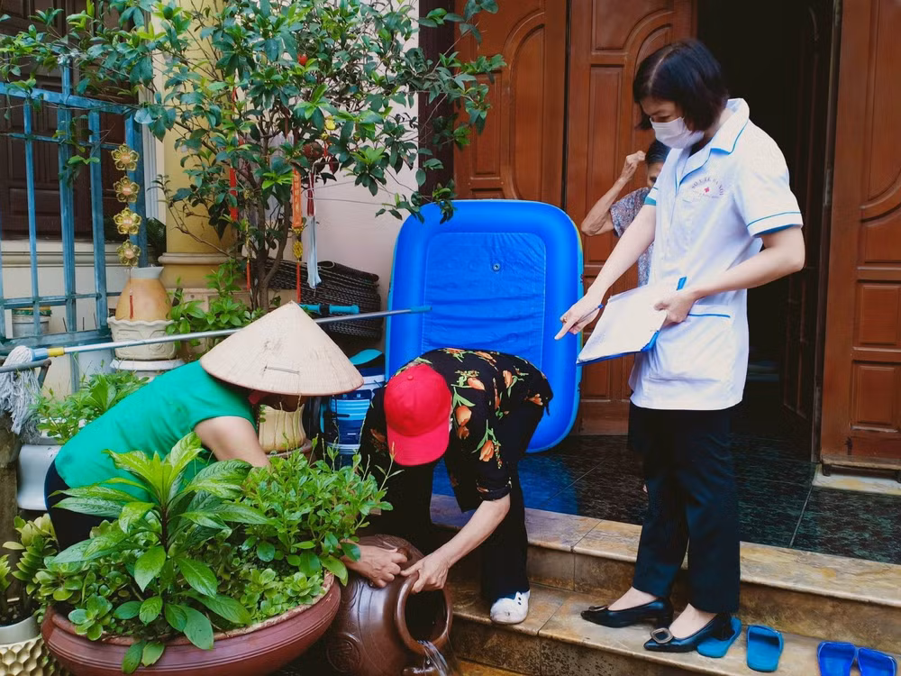 Cán bộ y tế phường Việt Hưng, quận Long Biên, Hà Nội hướng dẫn người dân diệt bọ gậy phòng sốt xuất huyết.