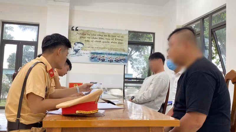 Cán bộ Phòng Cảnh sát Giao thông Công an tỉnh Quảng Nam làm việc với 2 người nước ngoài vi phạm trật tự an toàn giao thông.