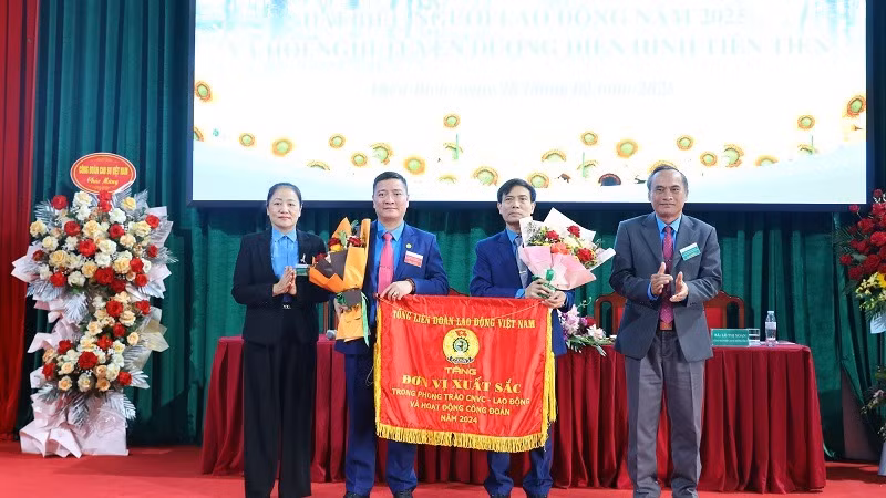 Thừa ủy quyền của Chủ tịch Tổng Liên đoàn Lao động Việt Nam, lãnh đạo Tập đoàn Công nghiệp cao-su Việt Nam và đại diện lãnh đạo Liên đoàn Lao động tỉnh Điện Biên trao Cờ thi đua tập thể lao động xuất sắc cho tập thể Công ty cổ phần cao-su Việt Nam. (Ảnh: TRUNG KIÊN)