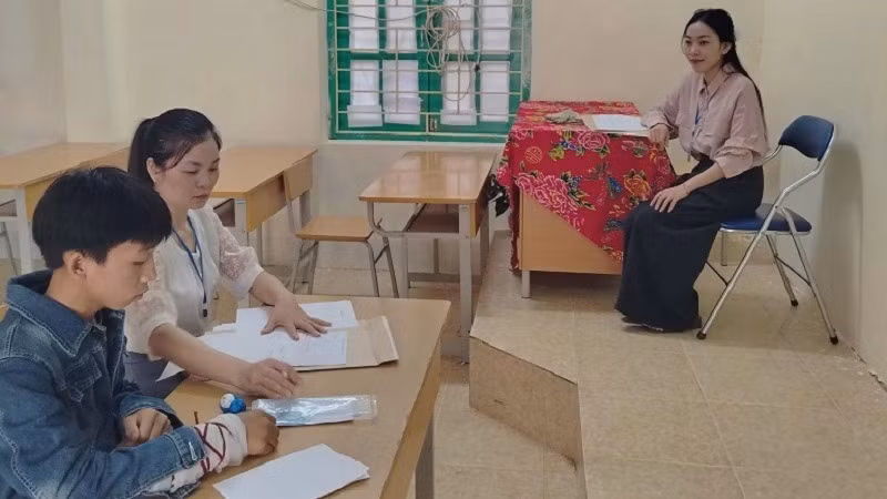 Thí sinh Thào A Dũng được hai giám thị hỗ trợ làm bài thi vào lớp 10 tại Hội đồng thi trường trung học cơ sở-trung học phổ thông Quyết Tiến (huyện Tủa Chùa). 