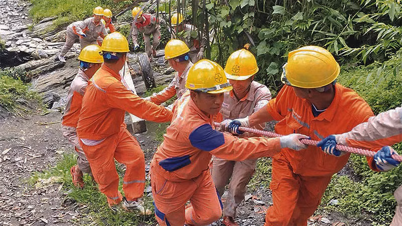 Công nhân Công ty Điện lực Hà Giang kéo điện lên vùng cao.