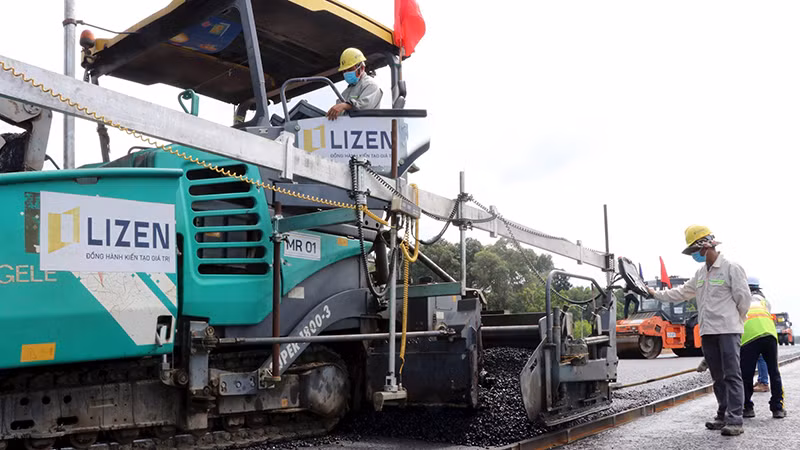 Nhà thầu tiến hành thảm nhựa lớp đầu tiên tại gói thầu số 21, thuộc dự án thành phần 1, đường cao tốc Biên Hòa-Vũng Tàu, đoạn qua tỉnh Đồng Nai. (Ảnh Công Phong)