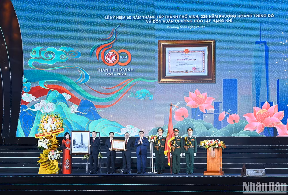 Chủ tịch Quốc hội Vương Đình Huệ trao Huân chương Độc lập hạng Nhì, tặng hoa, trao tặng bức tranh lưu niệm “Chủ tịch Hồ Chí Minh thăm công trường xây dựng Nhà máy điện Vinh (6/1957) cho Đảng bộ, chính quyền và nhân dân thành phố Vinh. (Ảnh: Duy Linh)