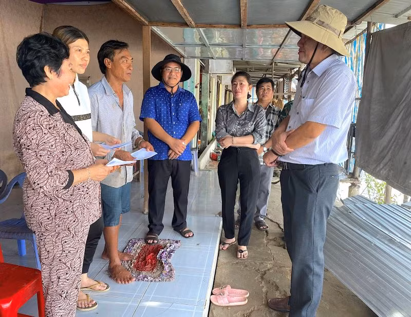 Bí thư Huyện ủy Năm Căn (tỉnh Cà Mau) Dư Minh Hùng (bìa phải) thăm hỏi, động viên các hộ dân có nhà bị sạt lở ở xã Tam Giang. 