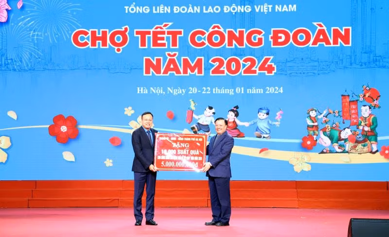Đồng chí Đinh Tiến Dũng, Bí thư Thành ủy Hà Nội trao biển tượng trưng kinh phí tặng quà Tết cho đoàn viên, người lao động cho đồng chí Phạm Quang Thanh, Chủ tịch Liên đoàn lao động thành phố Hà Nội.