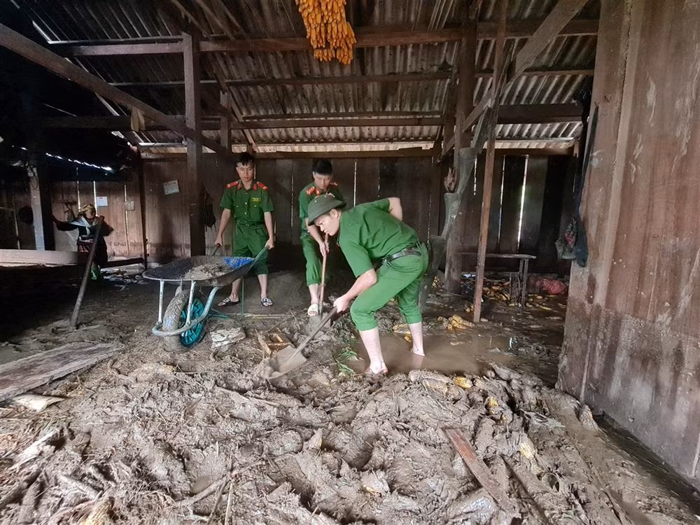 Công an huyện Than Uyên (Lai Châu) giúp dân xúc bỏ bùn đất tràn vào nhà tại bản Hô Ta, xã Tà Mung.