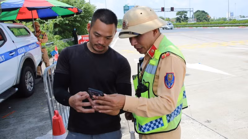 Cảnh sát giao thông kiểm tra giấy phép lái xe của chủ phương tiện qua ứng dụng VNeID.