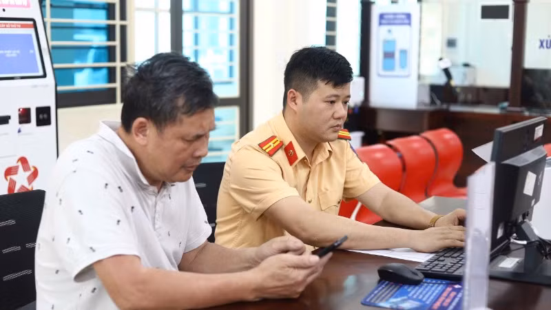 Cán bộ Phòng Cảnh sát giao thông Lào Cai hướng dẫn người dân cấp đổi giấy phép lái xe trên môi trường điện tử.