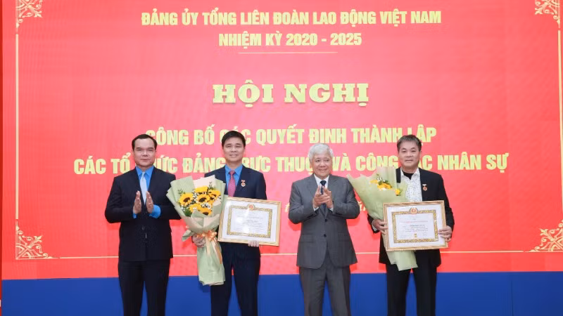 Đồng chí Đỗ Văn Chiến và đồng chí Nguyễn Đình Khang gắn huy hiệu 30 năm tuổi Đảng và tặng hoa chúc mừng các đồng chí đảng viên.