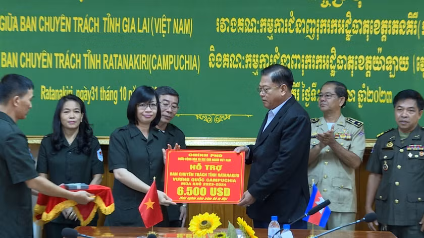 Phó Chủ tịch Ủy ban nhân dân tỉnh Gia Lai Nguyễn Thị Thanh Lịch (trái) trao tiền hỗ trợ của Chính phủ Việt Nam cho Ban Chuyên trách tỉnh Ratanakiri. (Ảnh: ĐỨC HẢI)