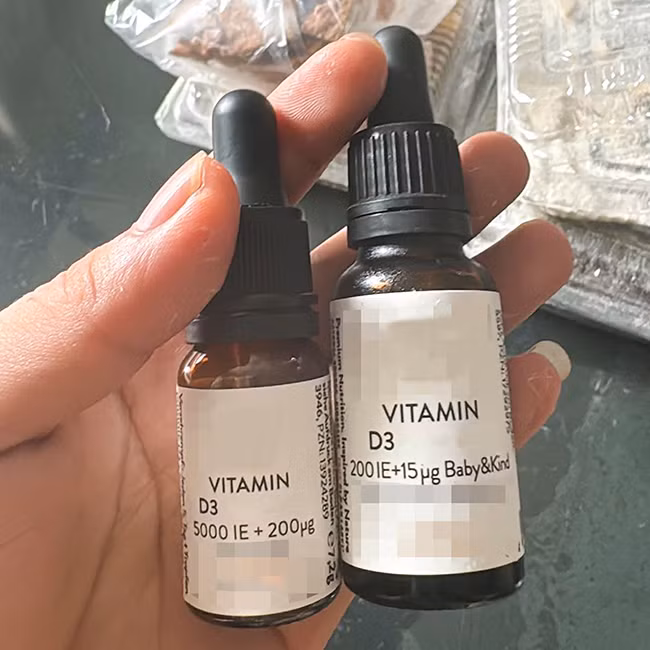 Lọ vitamin D 5000 IE +200 μg dành cho người lớn (bên trái) mà trẻ được cho uống nhầm ( Ảnh gia đình cung cấp).