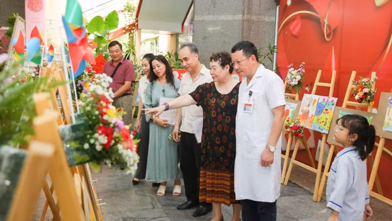 Các đại biểu tham quan triển lãm tranh vẽ của các bạn nhỏ mắc bệnh thalassemia.