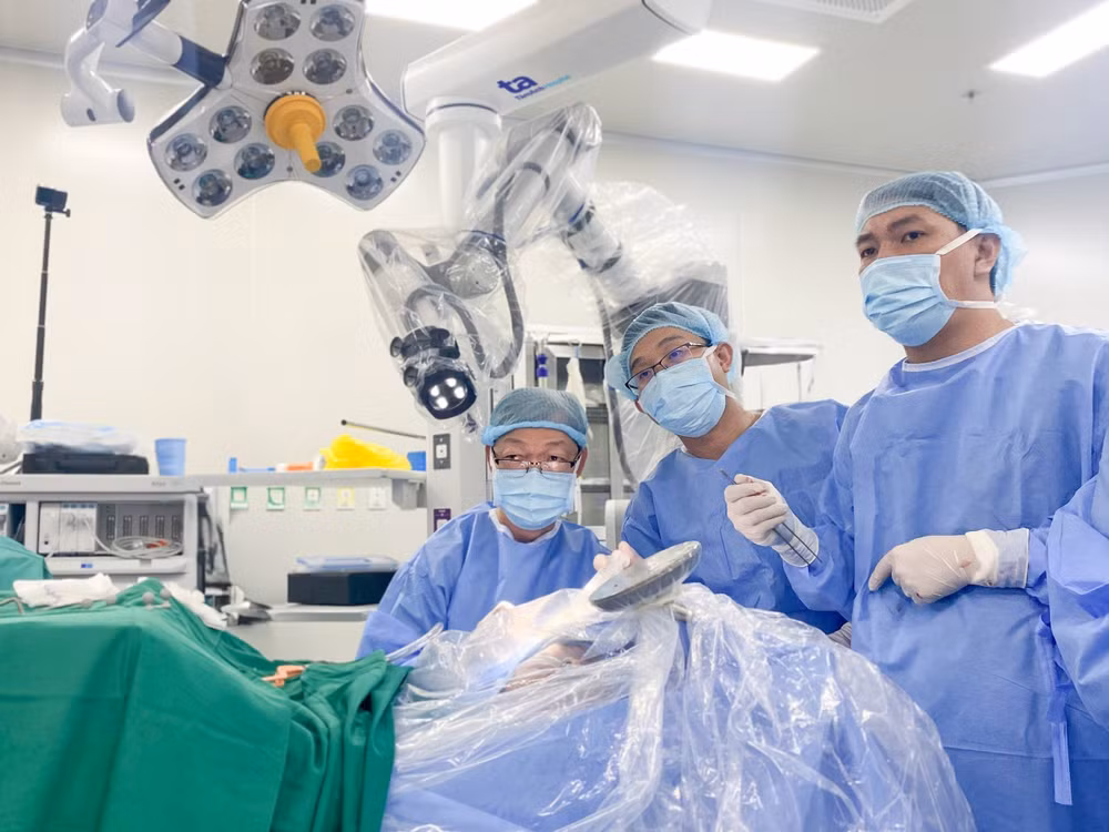 Bác sĩ Tấn Sĩ (người ngồi) và cộng sự trong ca mổ não tỉnh thức cho người bệnh bằng Robot Modus V Synaptive.