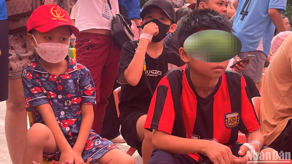 Bé Vũ Xuân P. (bên trái) và T.T.T (bên phải) chăm chú theo dõi chương trình.
