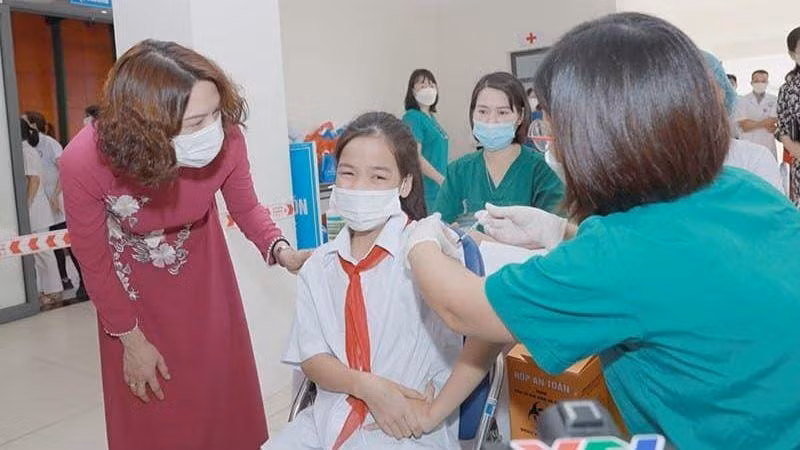 Thứ trưởng Nguyễn Thị Liên Hương động viên các em học sinh tham gia tiêm chủng.